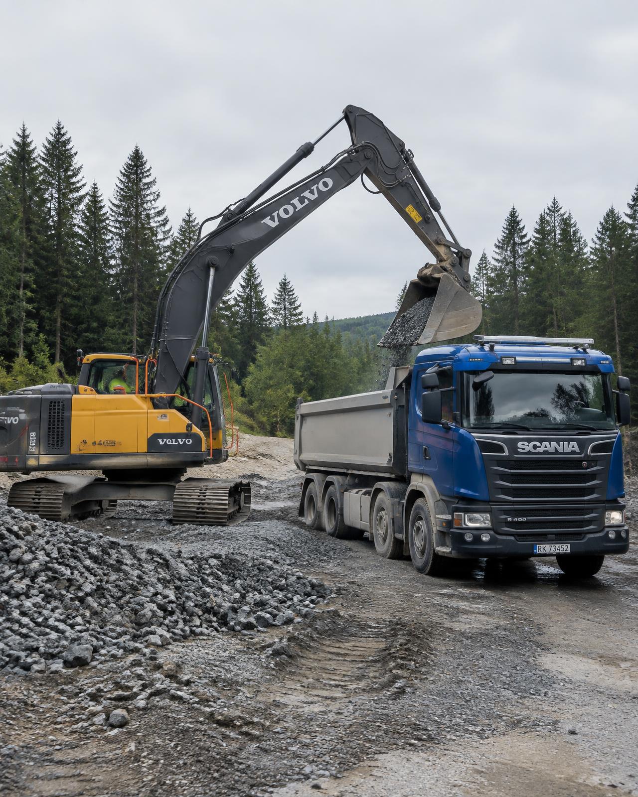 Gravemaskin laster masser på lastebil